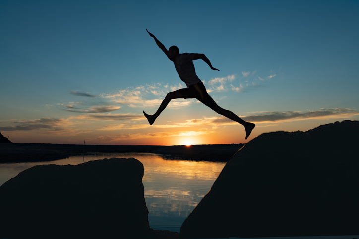 Man jump through the gap between hill.