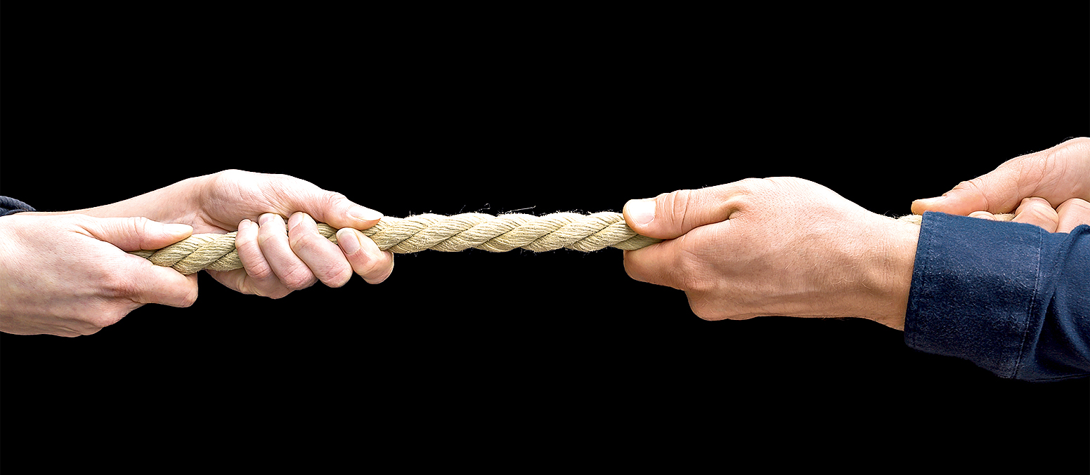 Male and female hands pull on a rope as a metaphor for divorce or power relations in a relationship