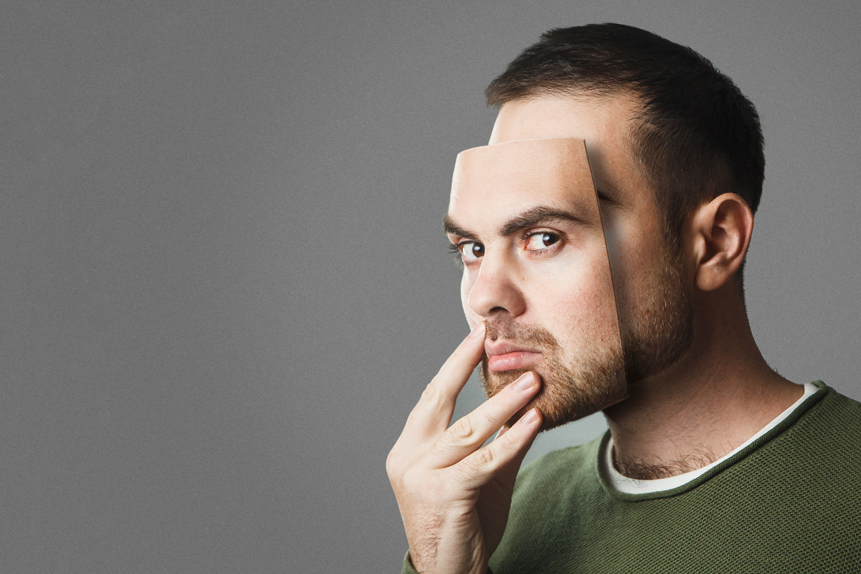 Be Yourself. Handsome man holds a mask of his face