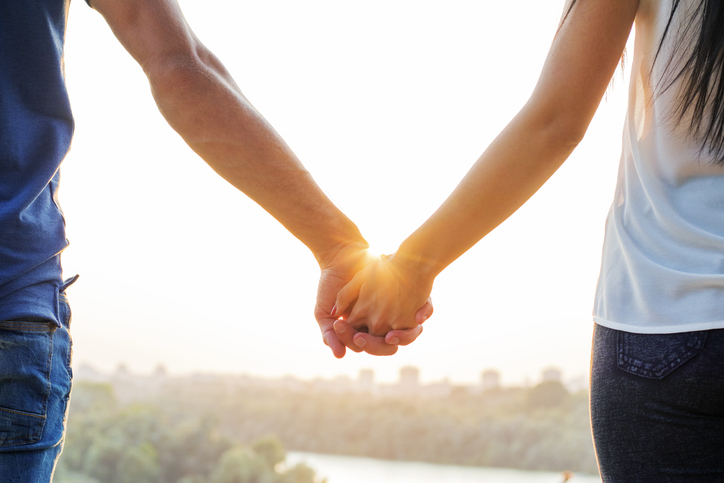 Couple holding hands at sunset