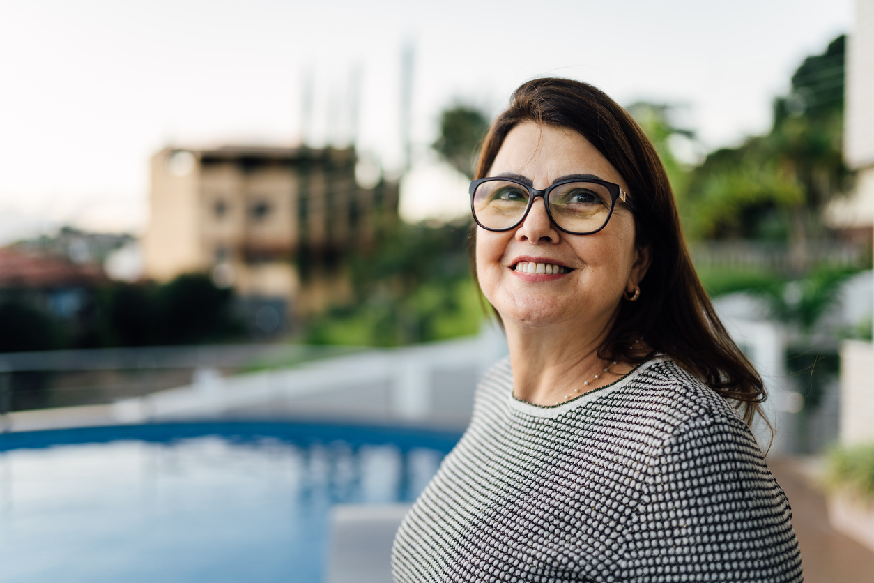 Mature woman looking to the side in front a swimming pool