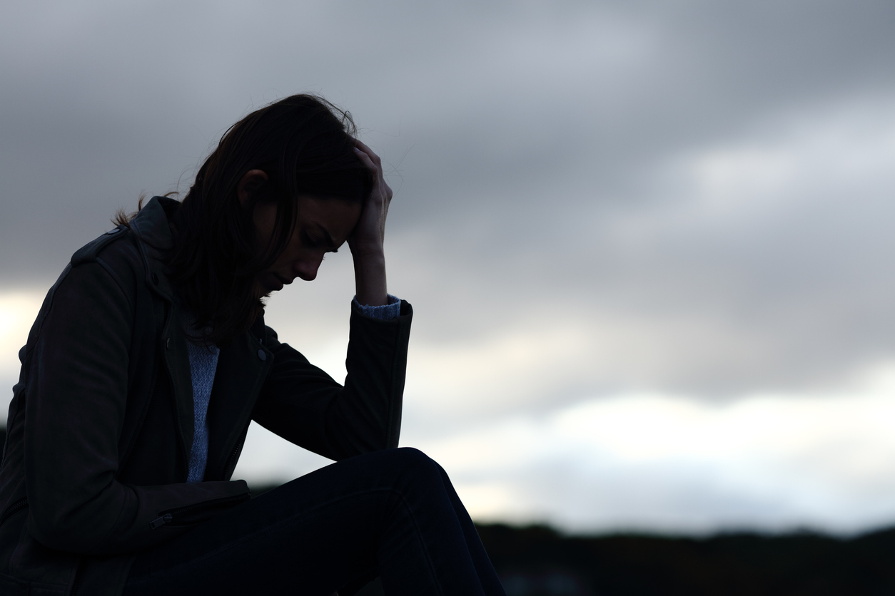 Profile of a sad woman silhouette complaining outdoors