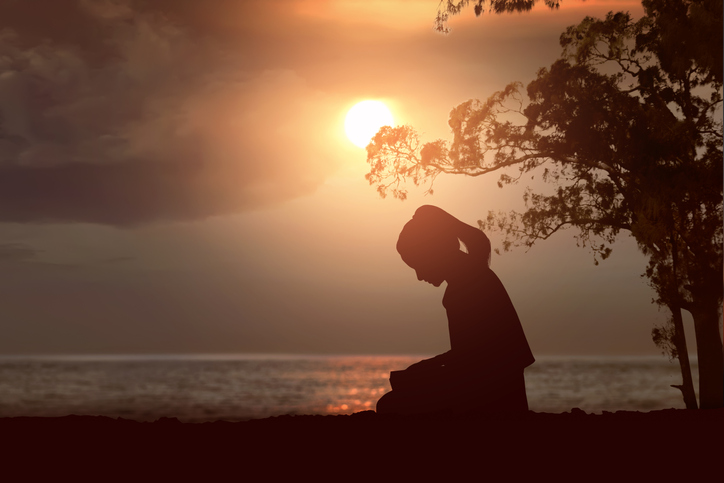 Silhouette of woman read the bible on the beach