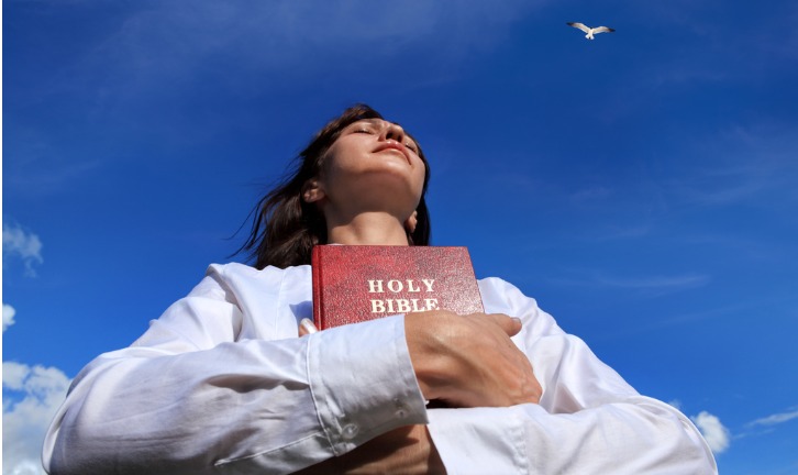 christian-woman-holding-on-to-the-holy-bible-picture-id1193838193