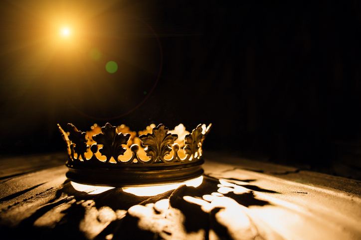 The crown on a black background is illuminated by a golden beam. Low-key image of a beautiful queen / royal crown Vintage is filtered. Fantasy of the medieval period. Battle for the Throne.