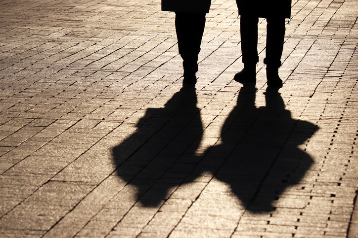 Silhouettes and shadows of couple walking down the street