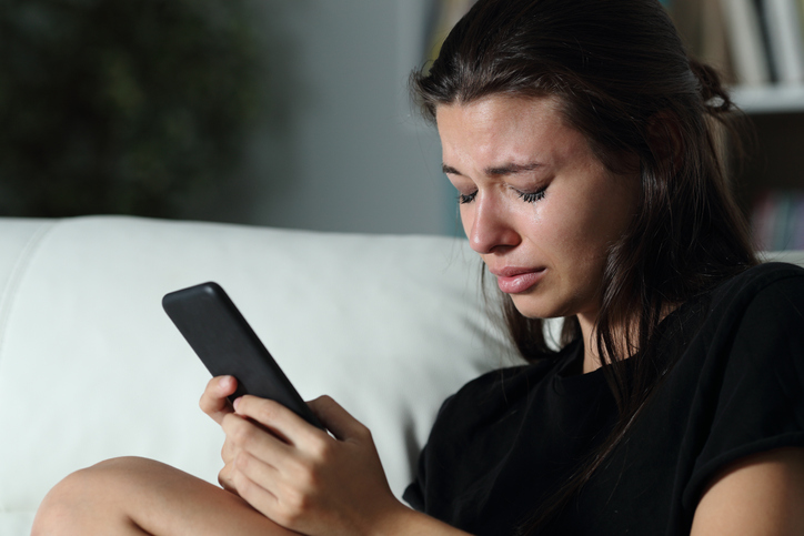 Sad teen crying after read phone message