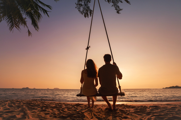 honeymoon travel, silhouette of romantic couple on sunset  beach