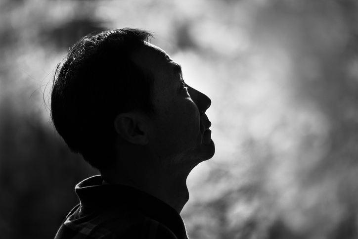 Black and white image of a man looking up with blurred background. Hope concept.