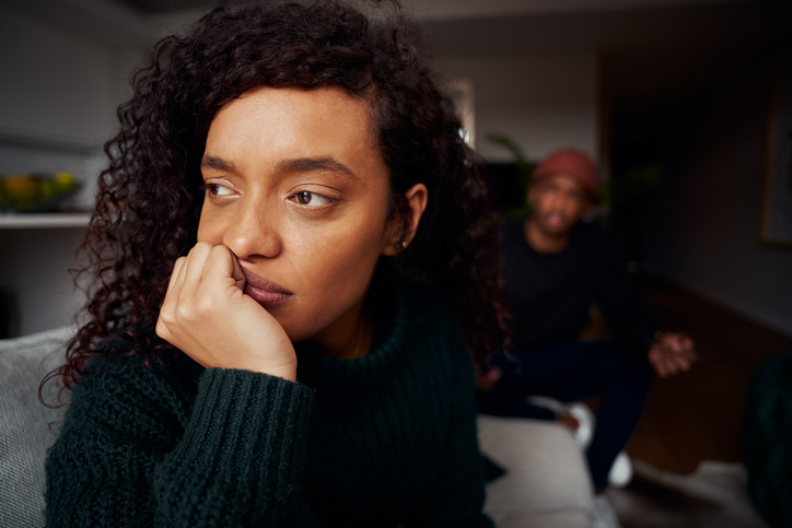 Close up of mixed race female ignoring black boyfriend while fighting on the sofa in modern apartment