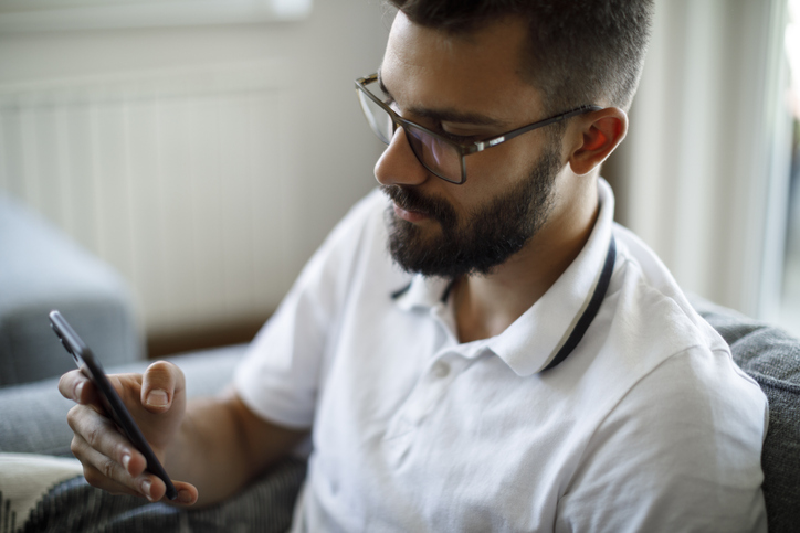 Young man using mobile phone at home
