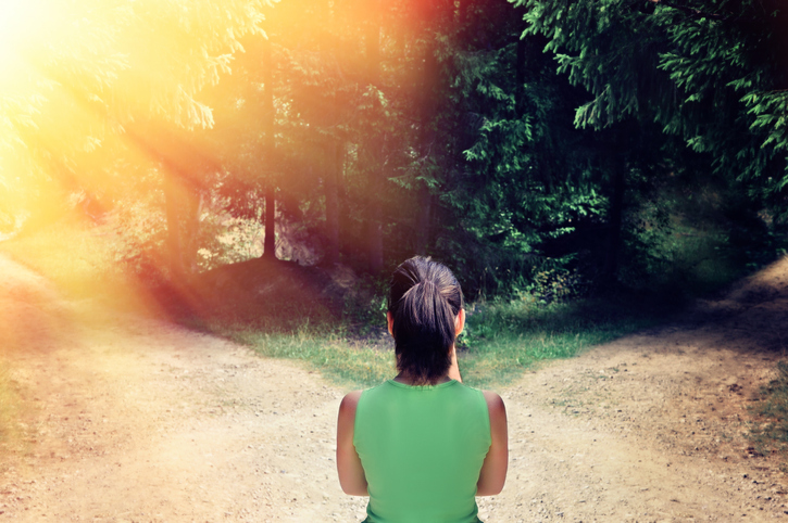 Girl with a choice near the forked road.The concept of the solution: the path to success and the path of risk