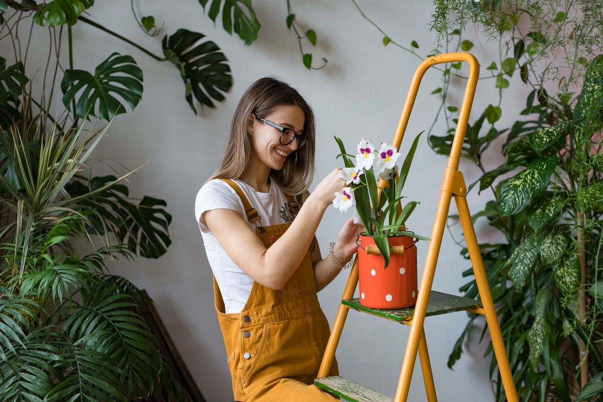 Young,Smiling,Woman,Gardener,In,Glasses,Wearing,Overalls,,Taking,Care