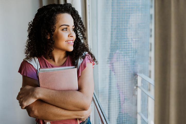 Woman embraced with bible in window light