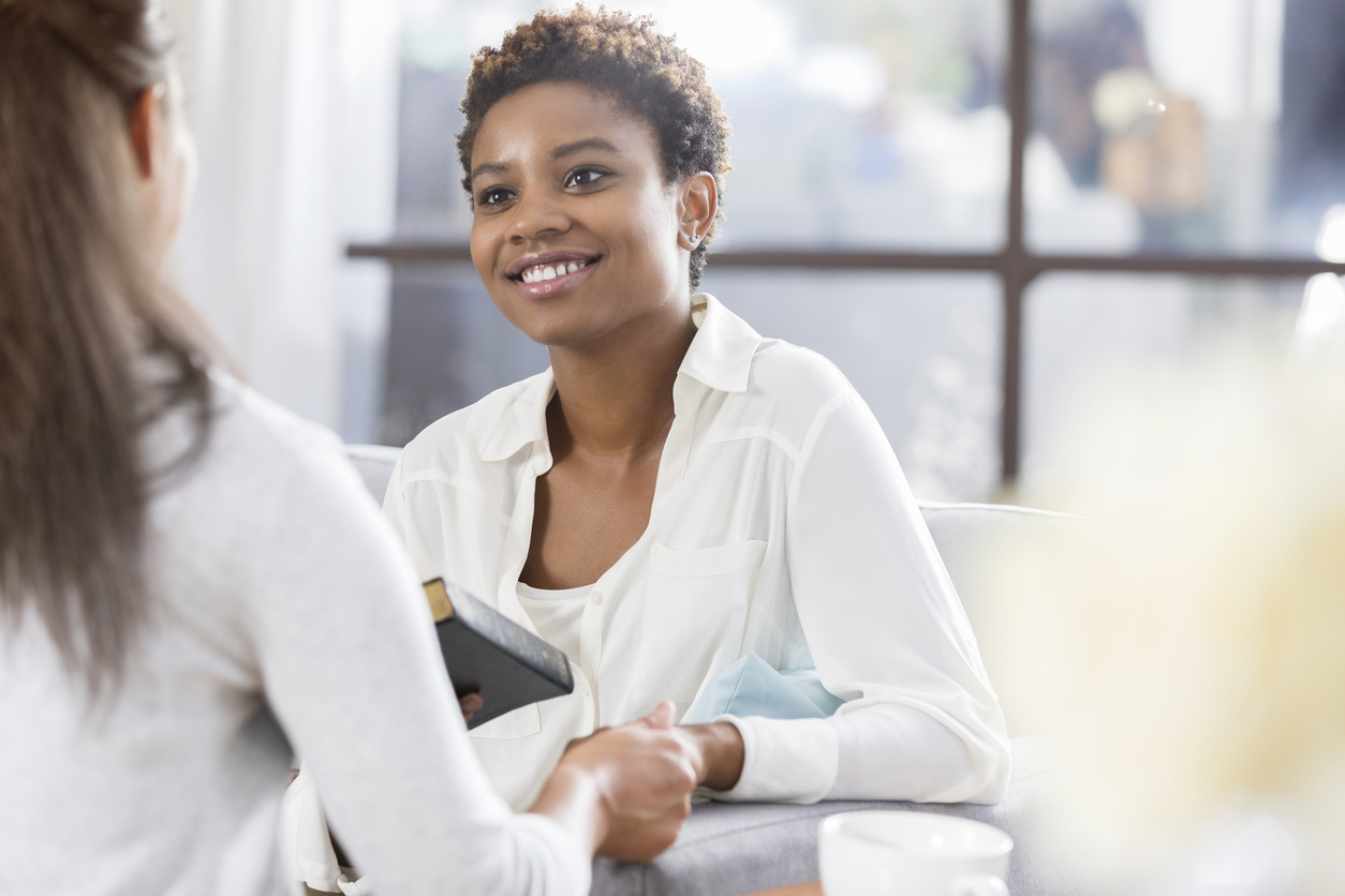 Unrecognizable woman gives her friend a Bible