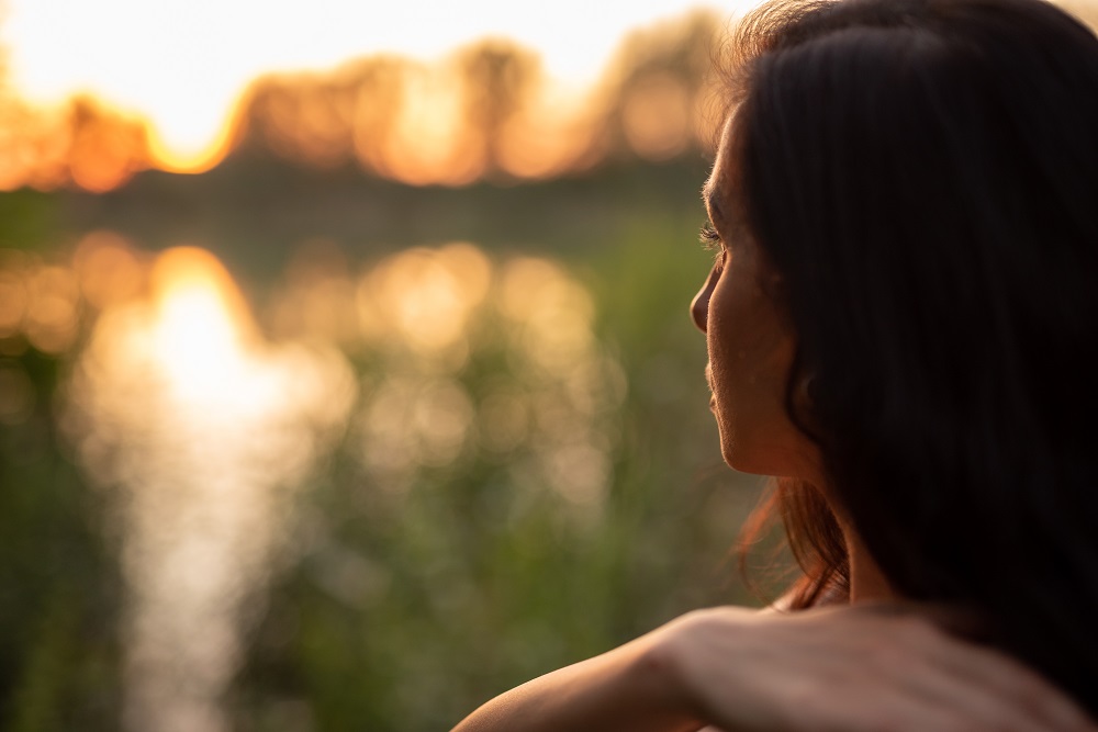 Young,Woman,With,Dark,Long,Hair,Looks,Towards,Sunset.,In