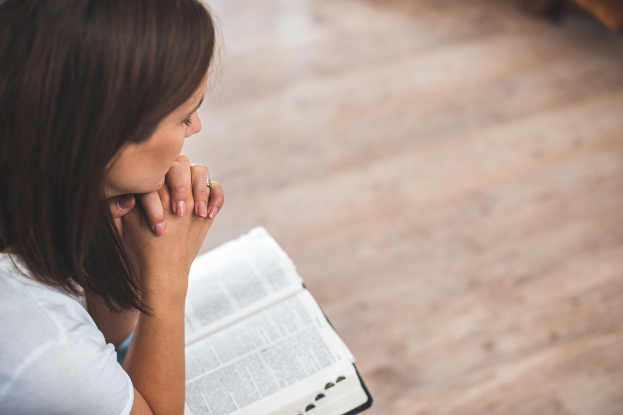 young woman pray with bible relationship with God at home
