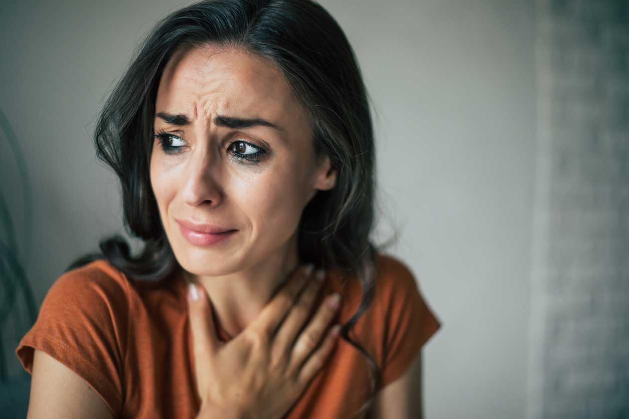 Sad woman in deep depression is sitting on the couch and crying and thinking about the bad thing
