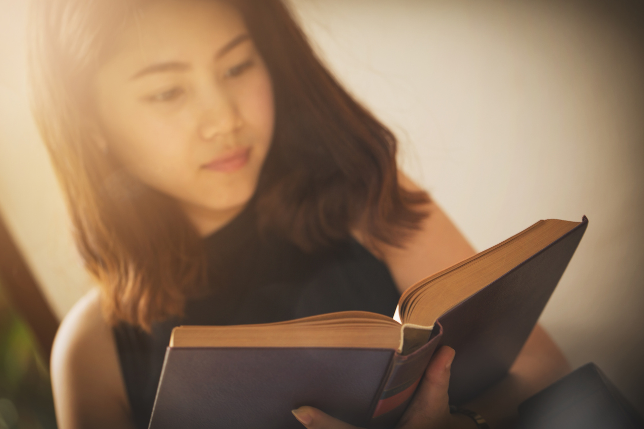 Asian woman reading a book vintage style.