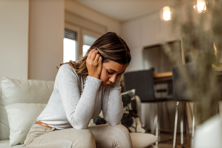 Stressed woman sitting on the sofa.