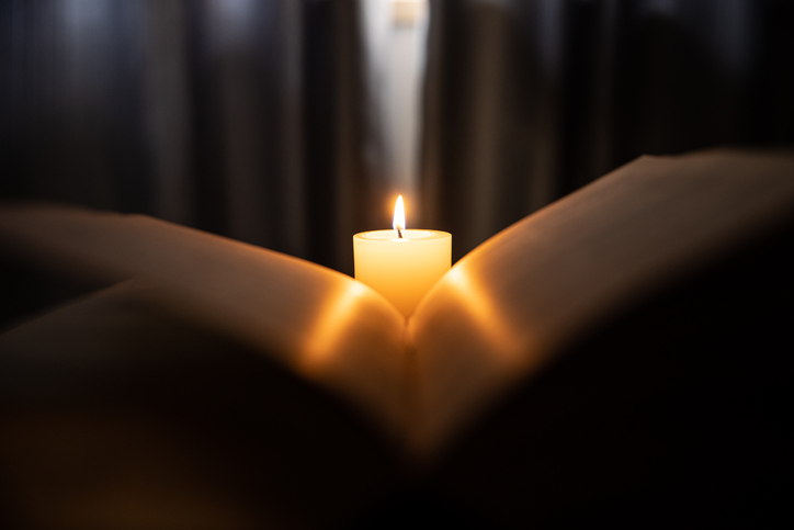 Candle light through ancient book