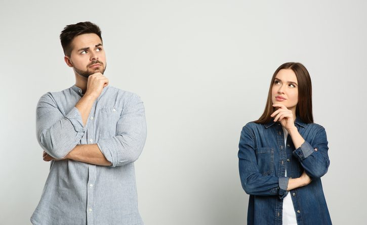 Pensive couple on light background. Thinking about answer for question