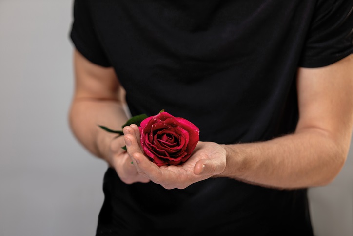 man with flower. young groom man gives red rose, romantic boy