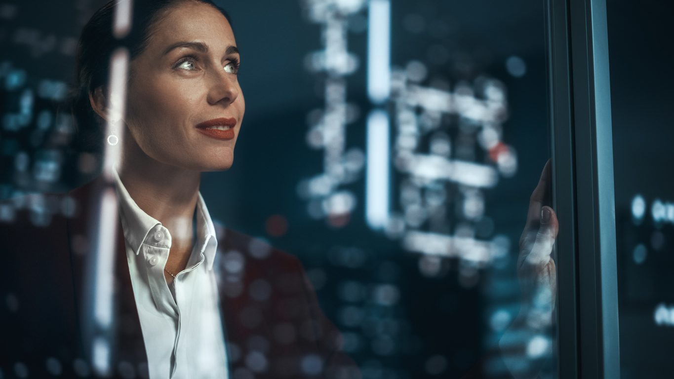 Office: Successful Businesswoman in Stylish Suit Working, Looking in Wonder at Night City. Stylish Female CEO Working Late and Hard to Create e-Commerce Online Shopping Experience Sustainable and Safe