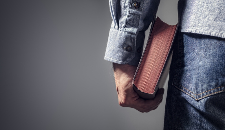 Man holding holy bible with gray background for text