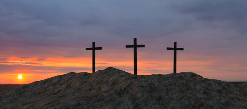 three crosses on top of a hill at sunset