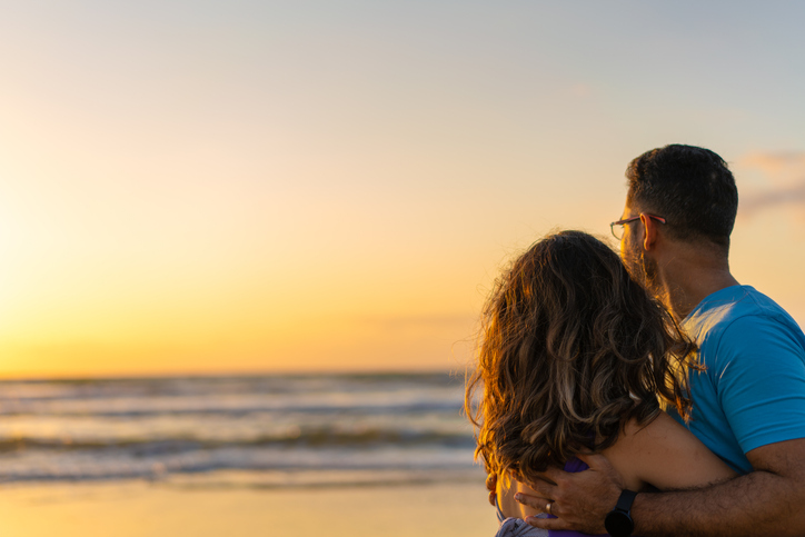 Couple enjoying sunrise on the beach