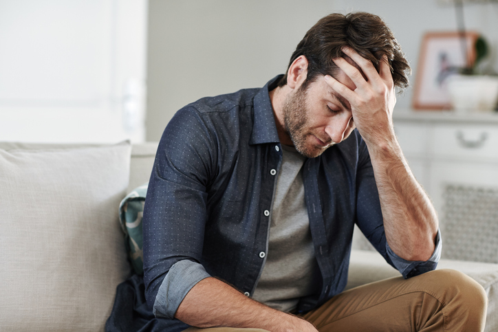 Man sitting alone at home looking sad and distraught