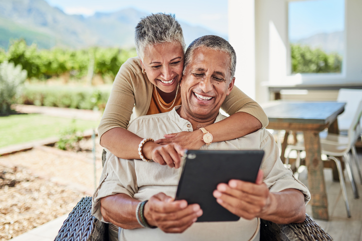 Outdoor, online and senior couple using a tablet for video call, internet and social media. Old man and woman with digital tech for chatting, call and texting on retirement home patio in Mexico