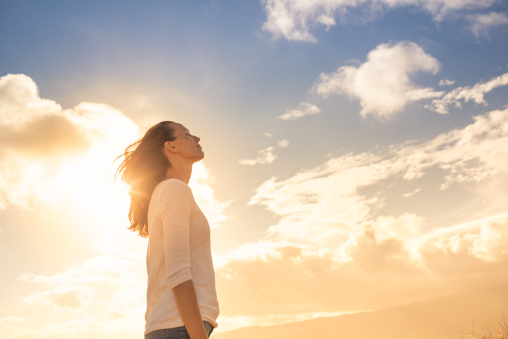 Woman looking up into the sky and thinking about her future.