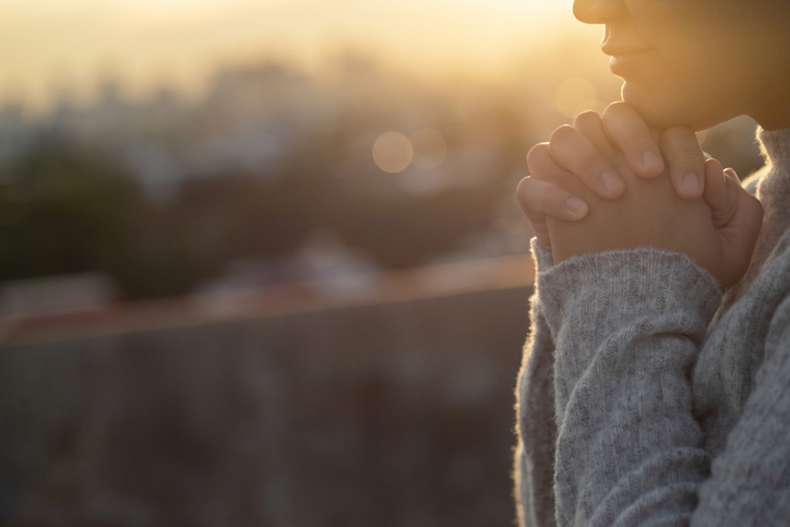 Women raise their hands to ask for blessing from God.