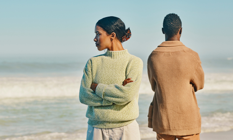 Couple, relationship and marriage problems while traveling together and spending time at the beach. Upset, unhappy and angry man and woman ignoring each other after a fight,  arguing or quarrel