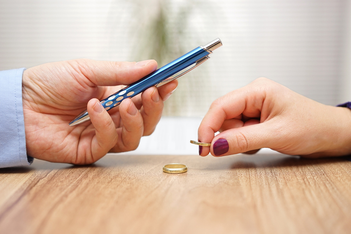 Husband is giving pen to sign divorce papers his wife