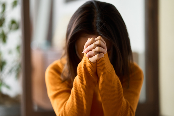 woman praying with her hands folded woman praying with her hands folded