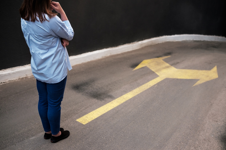 Young woman standing in front of two roads