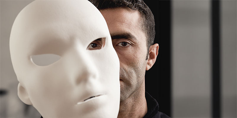 Adult Man Peeking Behind Mask In Vertical Composition