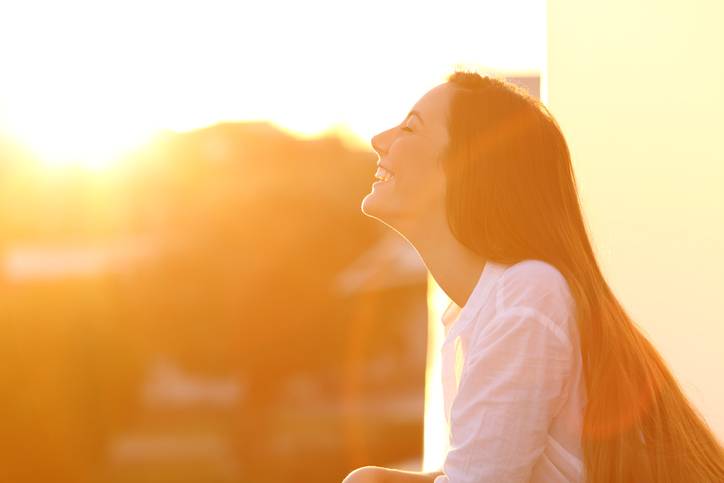 Woman breathing at sunset in a balcony