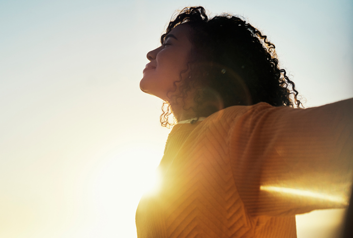 Freedom, flare and sky with a woman outdoor at sunset during summer to relax with fresh air and sunshine. Happy, carefree and mockup with a young female feeling relaxed outside in the morning