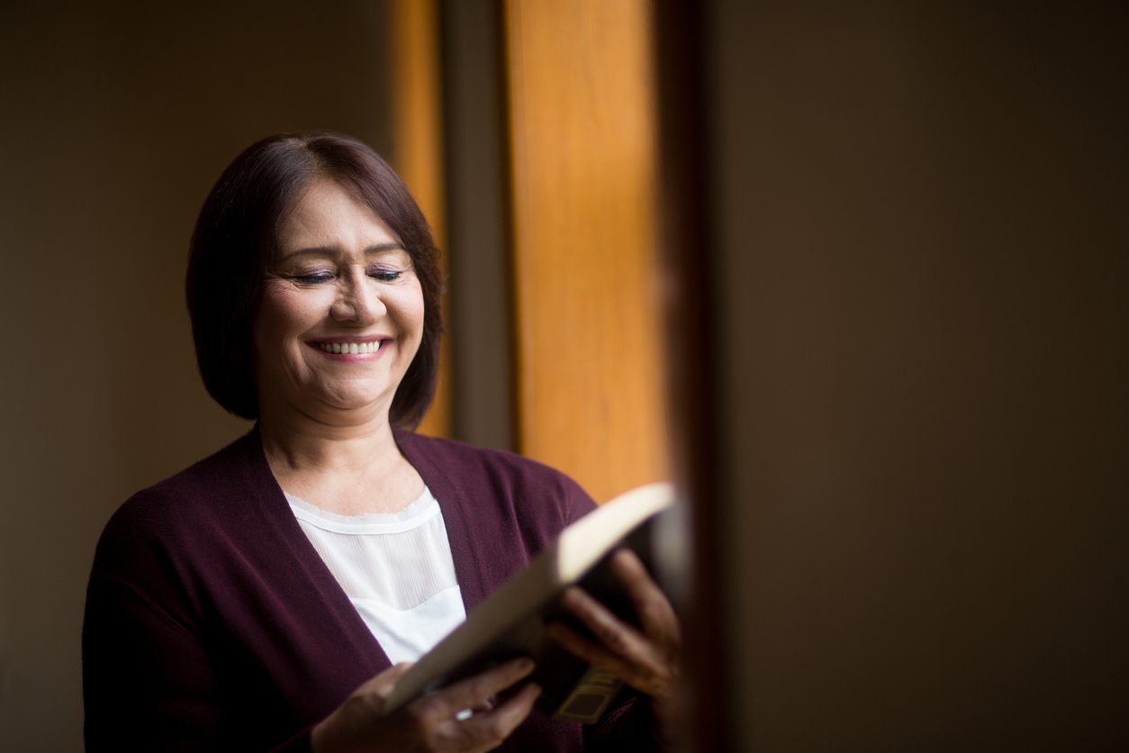 Happy mature woman reading book