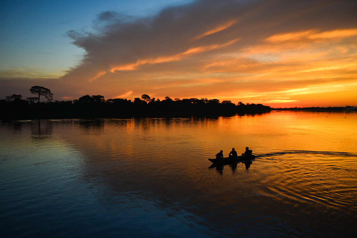 The silhouette of a small canoe on the Guaporé river at dusk