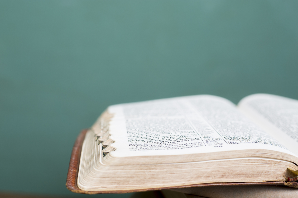 Stacks of Bibles and reference books for Spiritual studies.  Bibles in foreground are open to various scriptures.