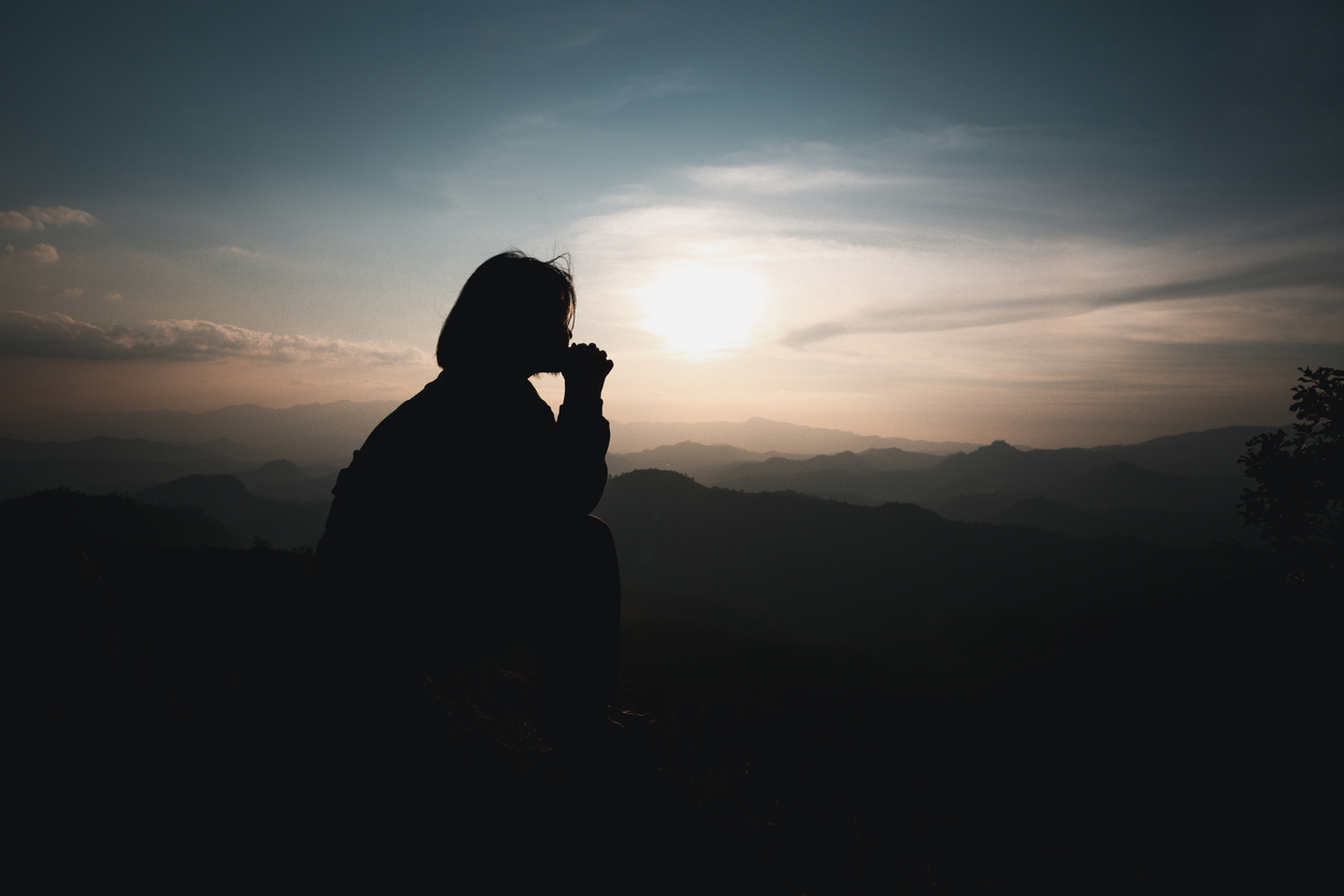 Faith christianity of christian worship concept. Spiritual prayer hands over sun shine with blurred beautiful sunset background. Woman praying to god with hopeful blessing against sunset.