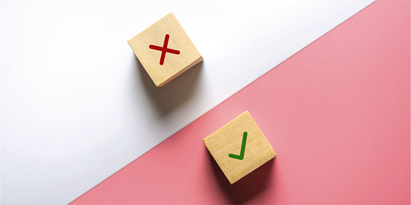 True and false symbols accept rejected for evaluation, Yes or No on wood blogs on pink and white background.