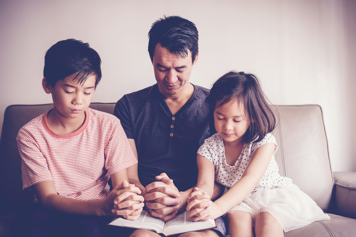 Multicultural asian children praying with their father at home, family pray