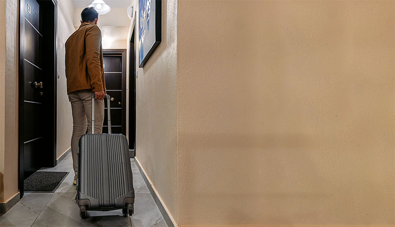 Young Man Entering A Hotel Room