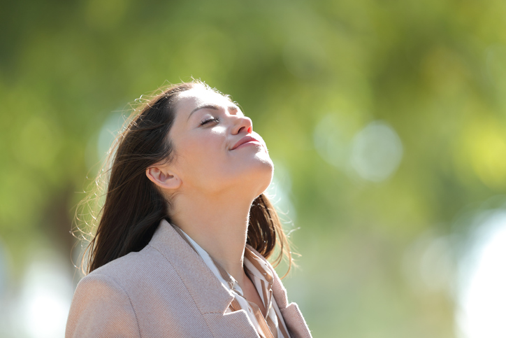 Woman breathing fresh air in a sunny park